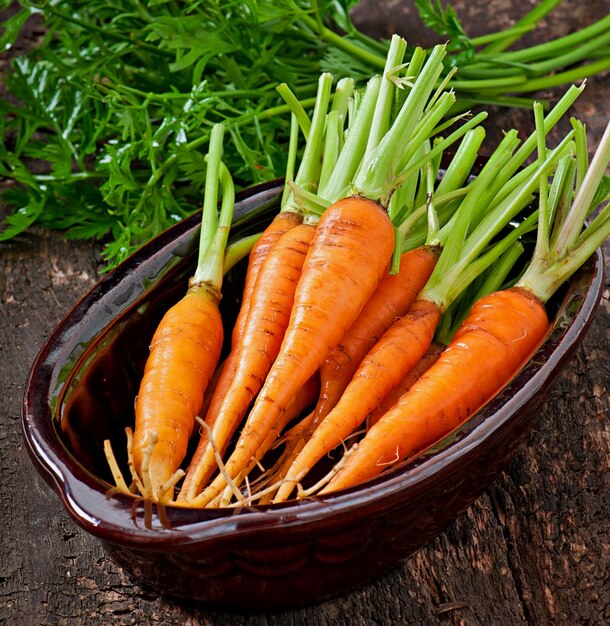 Fresh carrots on old wooden surface