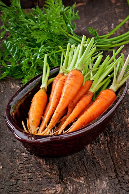 Fresh carrots on old wooden surface