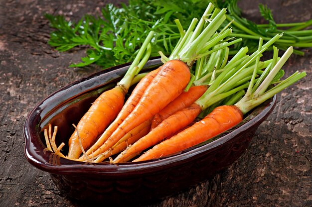 Fresh carrots on old wooden surface