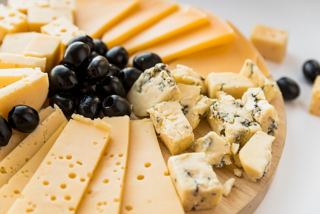 Fresh cheese and olives on chopping board