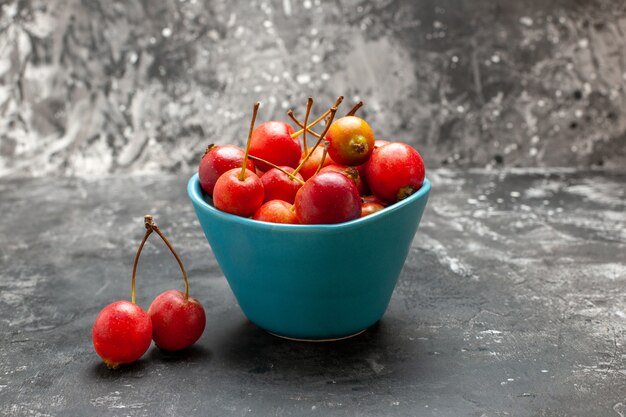 Fresh cherries inside and outside of a blue basket