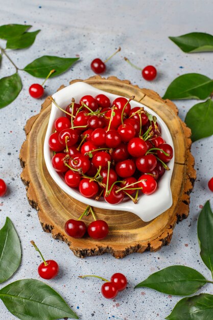 Fresh cherry on plate on grey table top view