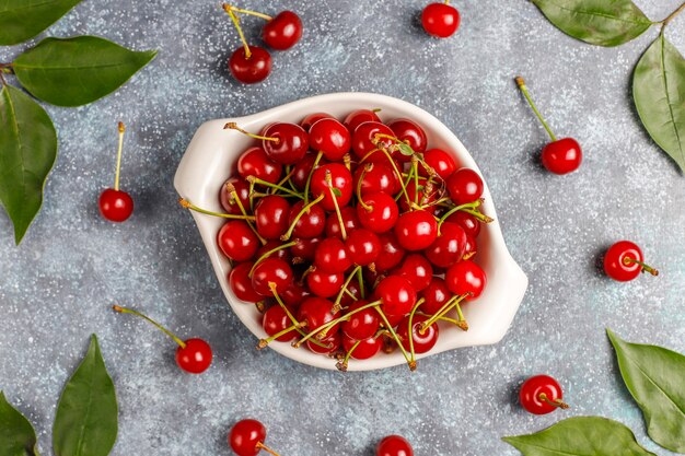 Fresh cherry on plate on grey table top view