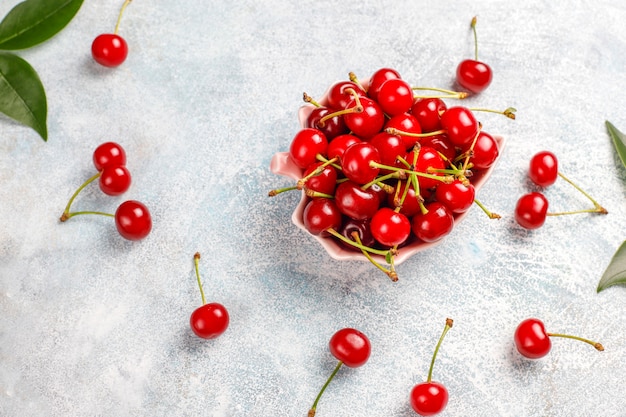 Fresh cherry on plate on grey table