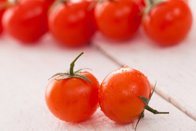 Fresh cherry tomatoes on a white surface 