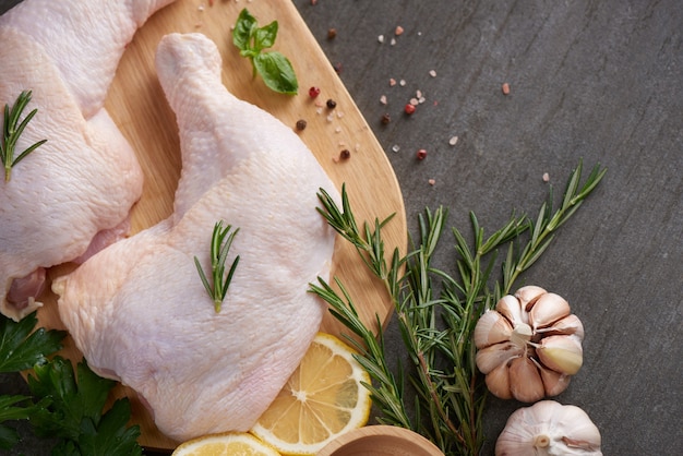 fresh chicken meat portions for cooking and barbecuing with fresh seasoning. Raw uncooked chicken leg on cutting board.