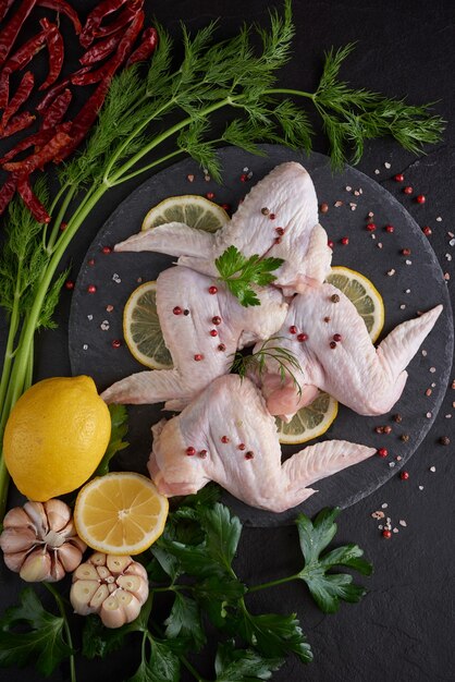 fresh chicken meat portions for cooking and barbecuing with fresh seasoning. raw uncooked chicken leg on cutting board.