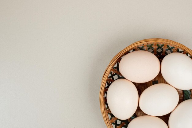 고리 버들 바구니에 신선한 닭고기 흰 계란입니다.