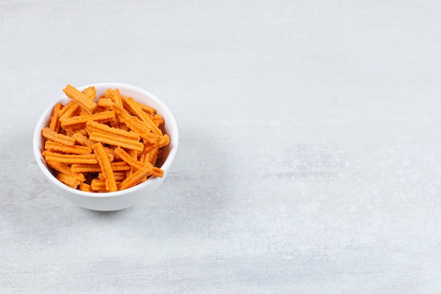 Fresh chips in white bowl over white