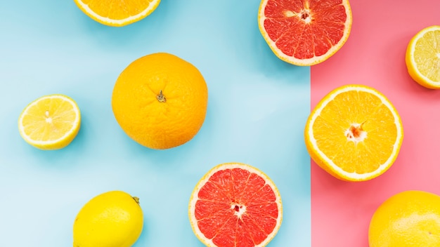 Fresh citrus fruits on dual colorful background