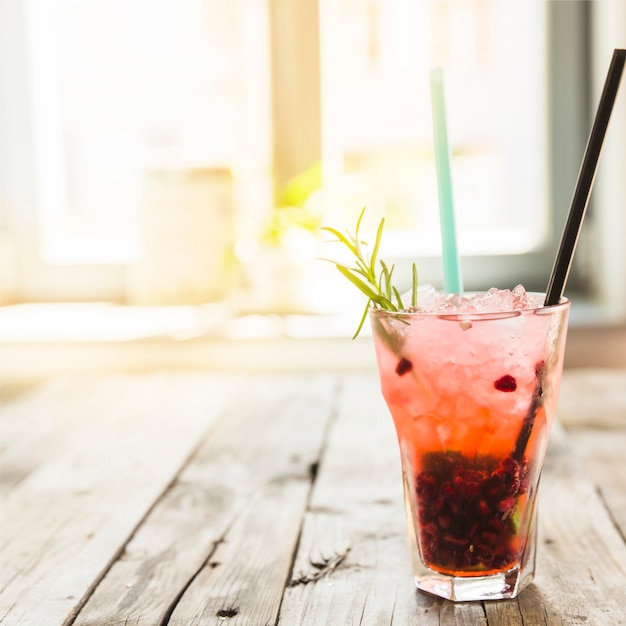 Fresh cocktail with ice on wooden desk