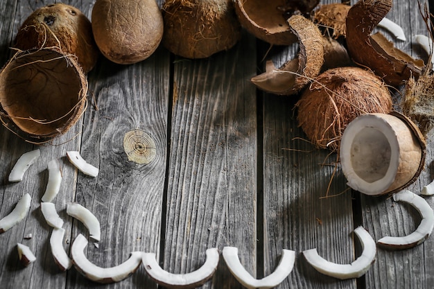 Foto gratuita noci di cocco fresche rotte sulla parete in legno