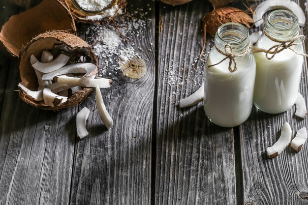 Noci di cocco fresche rotte sulla parete in legno