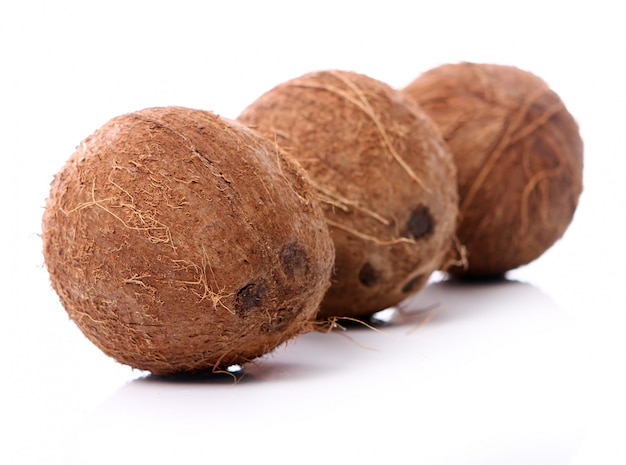 Fresh coconuts on white surface