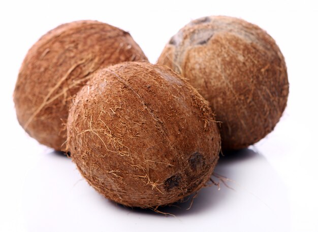 Fresh coconuts on white surface