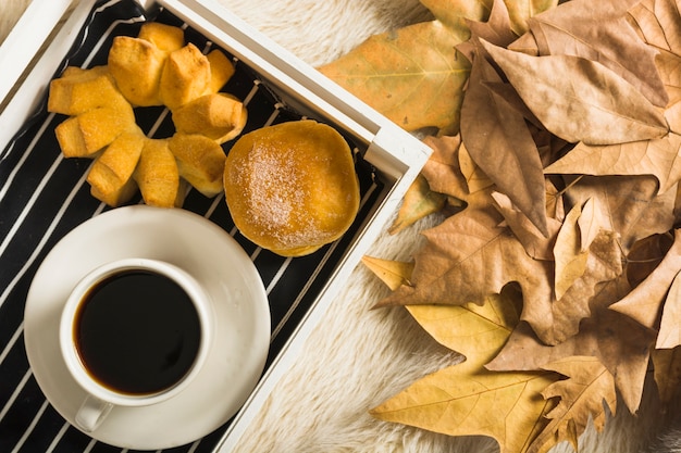 新鮮なコーヒーと葉のヒープの近くのパン