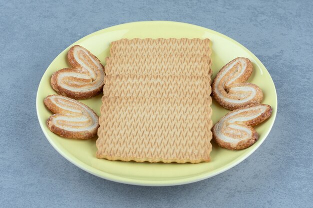 黄色のセラミックプレートに新鮮なクッキー。写真をクローズアップ。