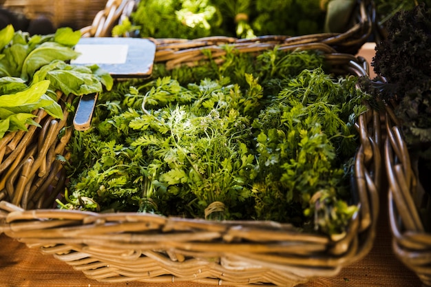 Fresh coriander in wicker basket for sale at supermarket