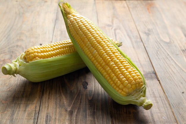 Free photo fresh corn on wooden table.