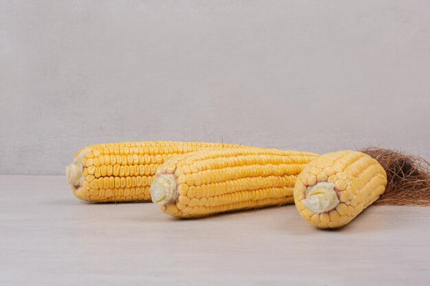 Fresh corns on cobs on white table.