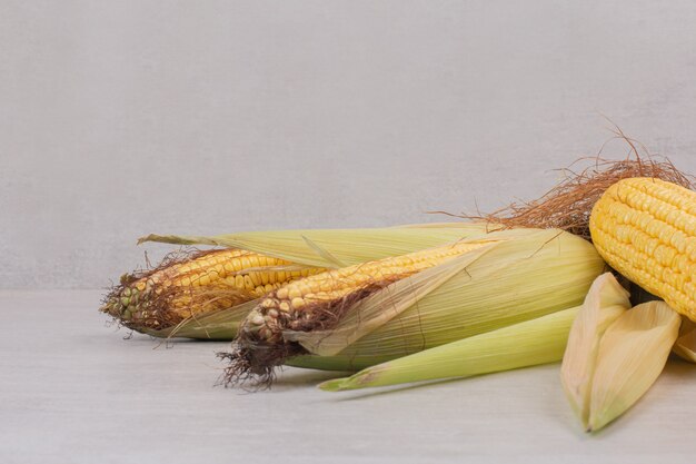 Fresh corns on cobs on white.