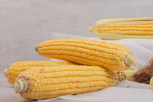 Free photo fresh corns on cobs on white.