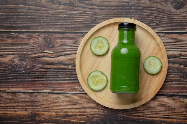 Fresh cucumber juice in a jar on dark wood background