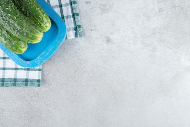 Fresh cucumbers on a blue board on a tablecloth. High quality photo