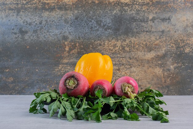 Fresh cucumbers, red radishes and pepper on stone table. High quality photo