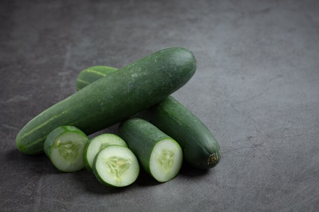 Fresh cucumbers sliced on dark background