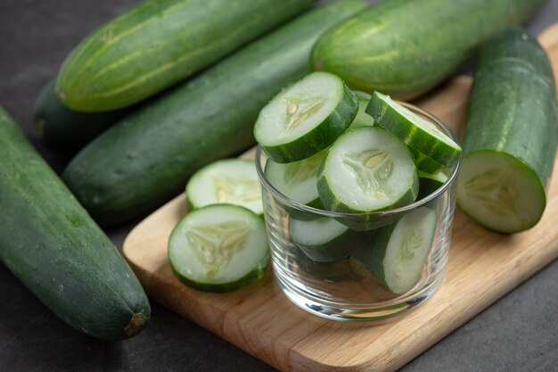 Fresh cucumbers sliced on dark background