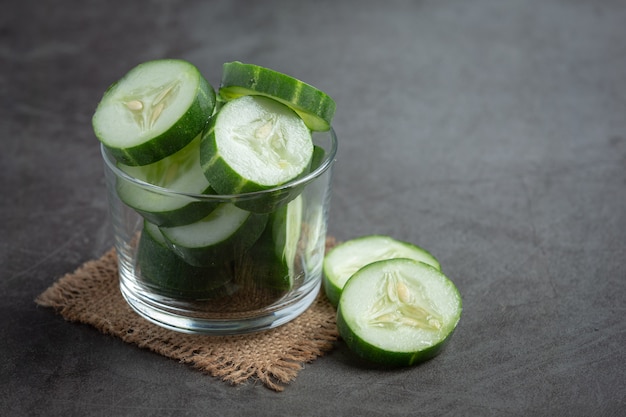 Fresh cucumbers sliced on dark background