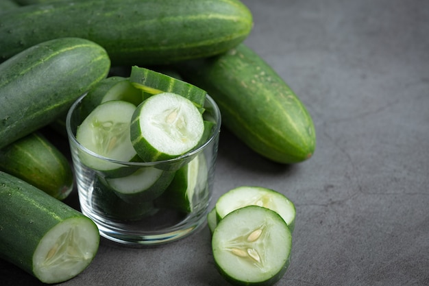 Fresh cucumbers sliced on dark background