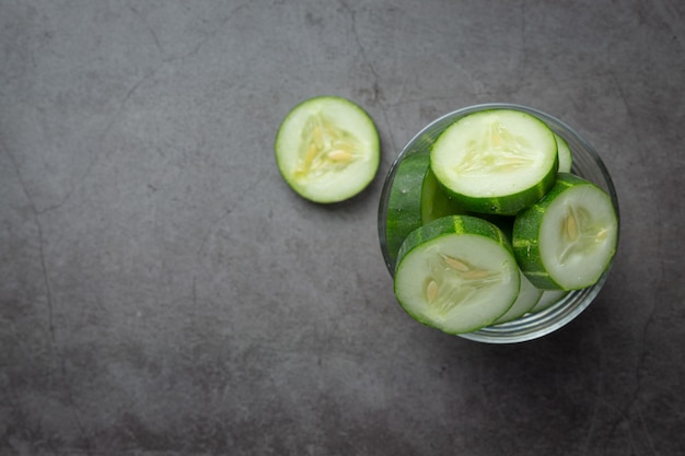 Fresh cucumbers sliced on dark background