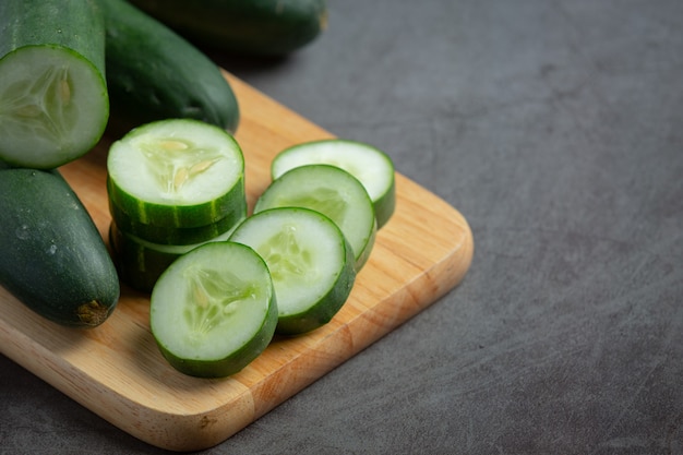 Fresh cucumbers sliced on dark background