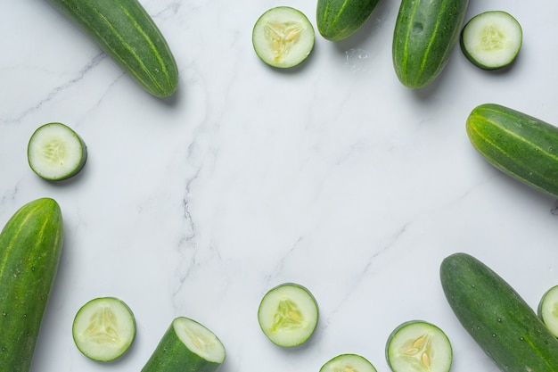 Fresh cucumbers sliced on marble background