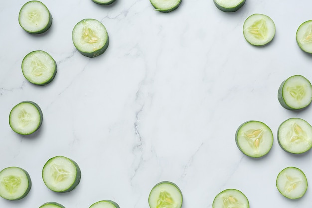 Fresh cucumbers sliced on marble background