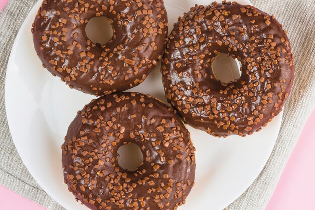 Fresh delicious chocolate doughnuts on plate