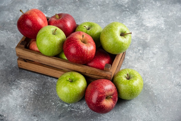 Fresh delicious green and red apples in wooden box. 