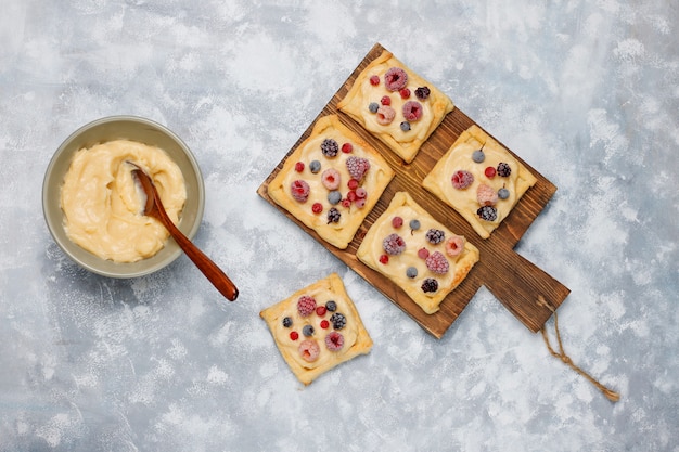 Fresh delicious puff pastry with sweet berries on concrete