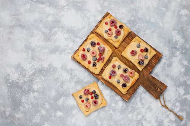 Fresh delicious puff pastry with sweet berries on concrete 