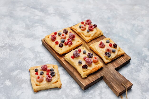 Fresh delicious puff pastry with sweet berries on concrete 