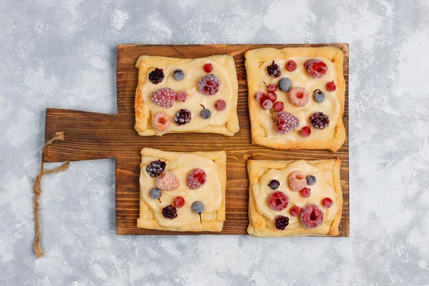 Fresh delicious puff pastry with sweet berries on concrete