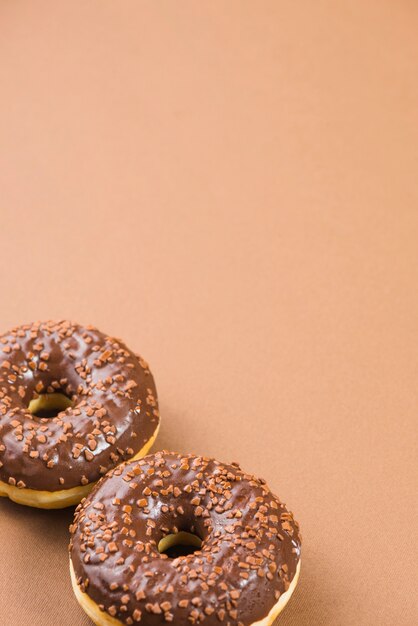 Fresh donuts with dark chocolate coating and sprinkles