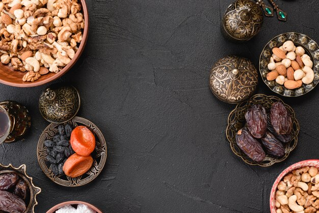 Fresh dried fruits; nuts and dates for ramadan on black backdrop