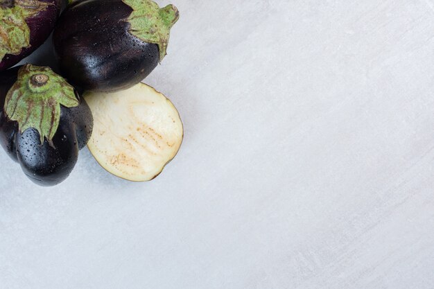 Fresh eggplants with water drops on stone surface. High quality photo