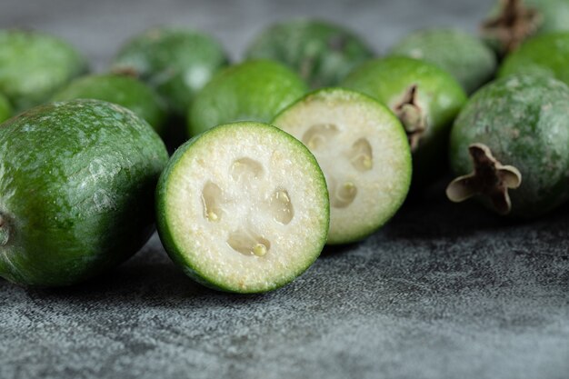 Fresh feijoa fruits on marble surface.