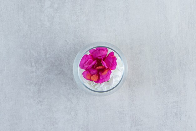 Fresh flowers in a glass vase, on the marble background. High quality photo