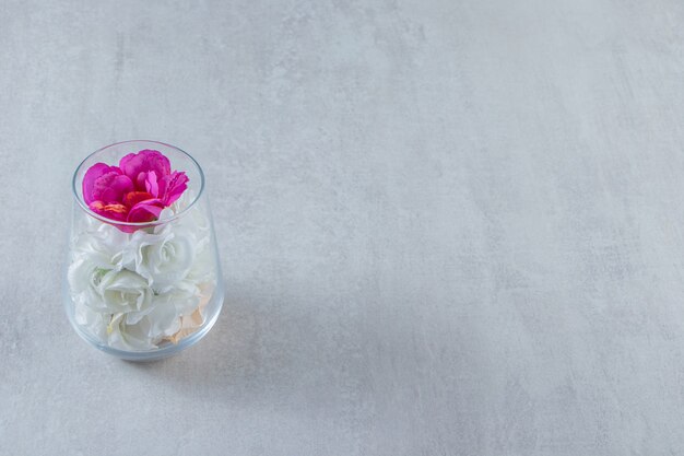 Живые цветы в стеклянной вазе на мраморном столе.