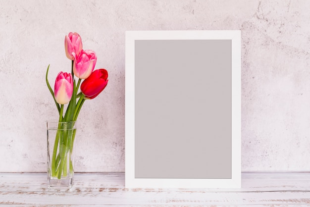 Fresh flowers in vase and frame
